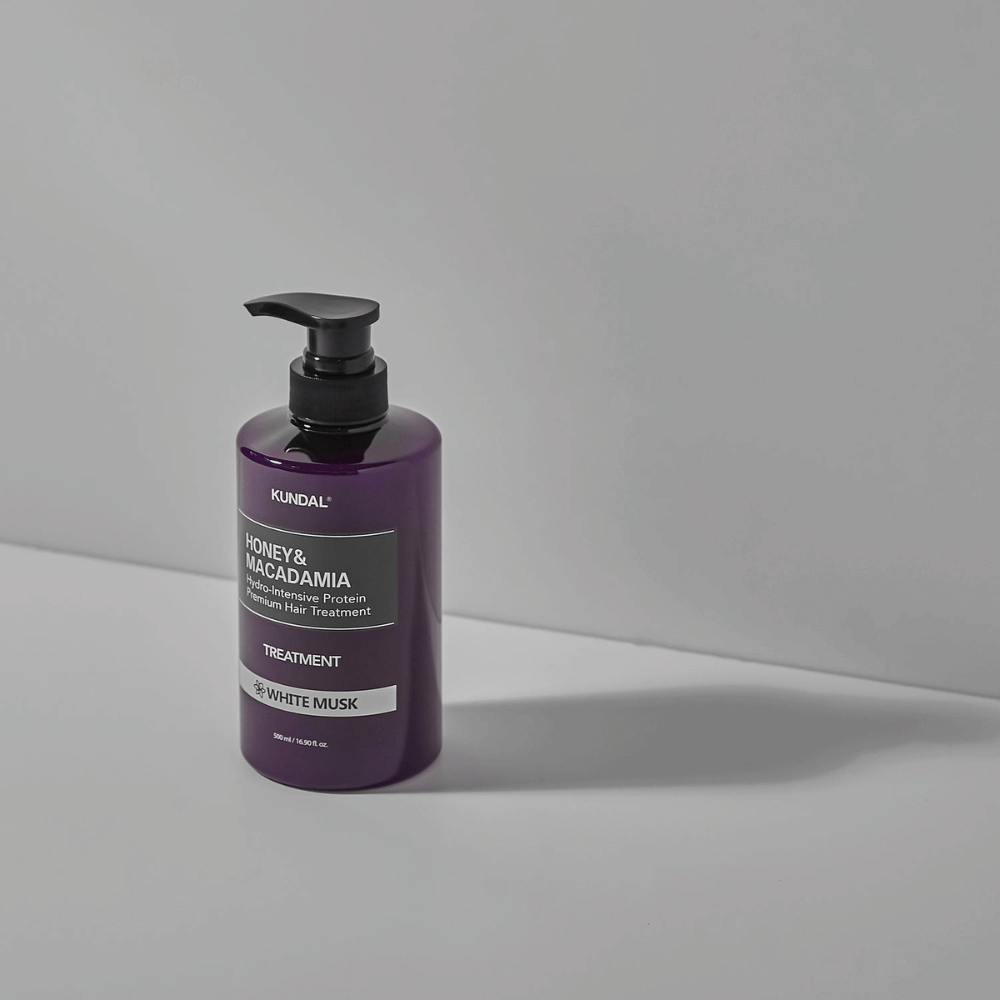 KUNDAL Μέλι & Μακαντάμια Υδρο-Εντατική Πρωτεΐνη Premium Μαλλιών Treatment Λευκός Μόσχος σε μοβ αντλία, 500 ml.
