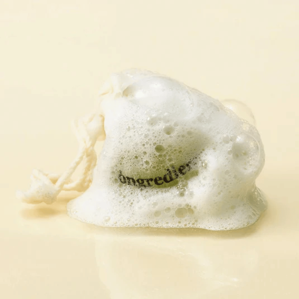 Óngredients Jeju Green Tea Cleansing Ball σε διχτυωτή τσάντα καλυμμένη με απαλό αφρό – φυσικό κορεάτικο σαπούνι προσώπου.