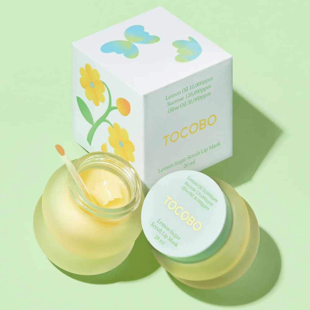 Tocobo Lemon Sugar Scrub Lip Mask μαζί με τη συσκευασία του με σχέδιο λουλουδιών σε ανοιχτό πράσινο φόντο.