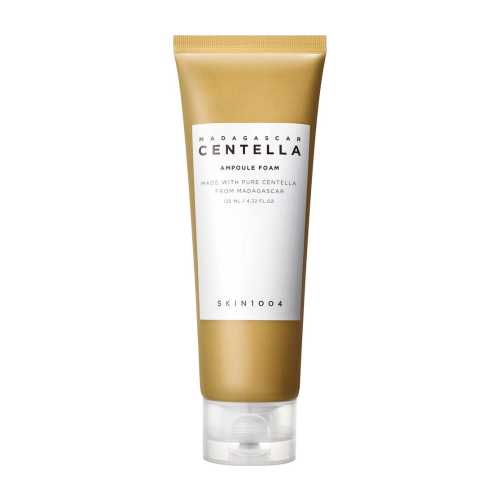 Η εικόνα δείχνει ένα σωληνάριο από "Madagascar Centella Ampoule Foam" από τη μάρκα SKIN1004. Είναι ένα καθαριστικό προϊόν για το πρόσωπο που περιέχει 125 ml / 4.22 fl.oz. Η φόρμουλα βασίζεται σε καθαρή Centella που εξάγεται από φυτά στη Μαδαγασκάρη. Το προϊόν έχει σχεδιαστεί για να καθαρίζει και να φροντίζει απαλά το δέρμα.