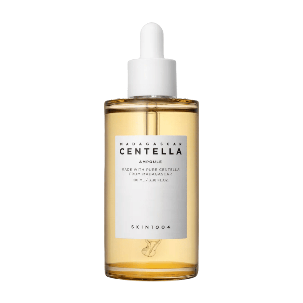 Η εικόνα δείχνει ένα μπουκάλι με "Madagascar Centella Asiatica 100 Ampoule" από SKIN1004. Το μπουκάλι περιέχει 100 ml και ισχυρίζεται ότι είναι φτιαγμένο με καθαρή Centella από τη Μαδαγασκάρη. Το προϊόν φαίνεται να είναι ένας ορός περιποίησης δέρματος και η απλή ετικέτα δίνει μια εντύπωση καθαρότητας και φυσικότητας. Το μπουκάλι με το σταγονόμετρο προτείνει ότι αυτό είναι ένα προσεκτικά δοσομετρημένο προϊόν περιποίησης δέρματος.