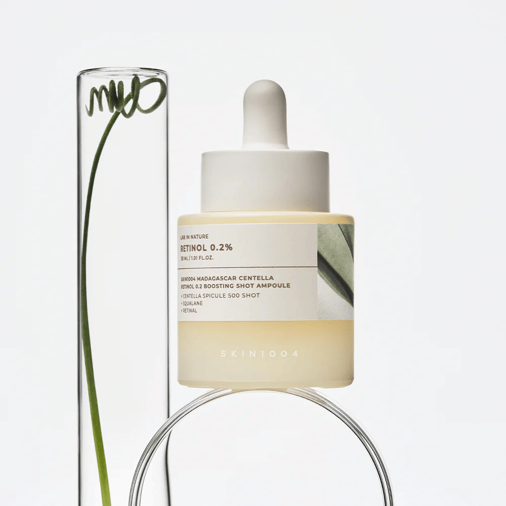 SKIN1004 Madagascar Centella Retinol 0.2 Boosting Shot Ampoule σε lifestyle εικόνα με βότανα – ορός προσώπου που υποστηρίζει την ανανέωση του δέρματος και ενισχύει το φραγμό του δέρματος.