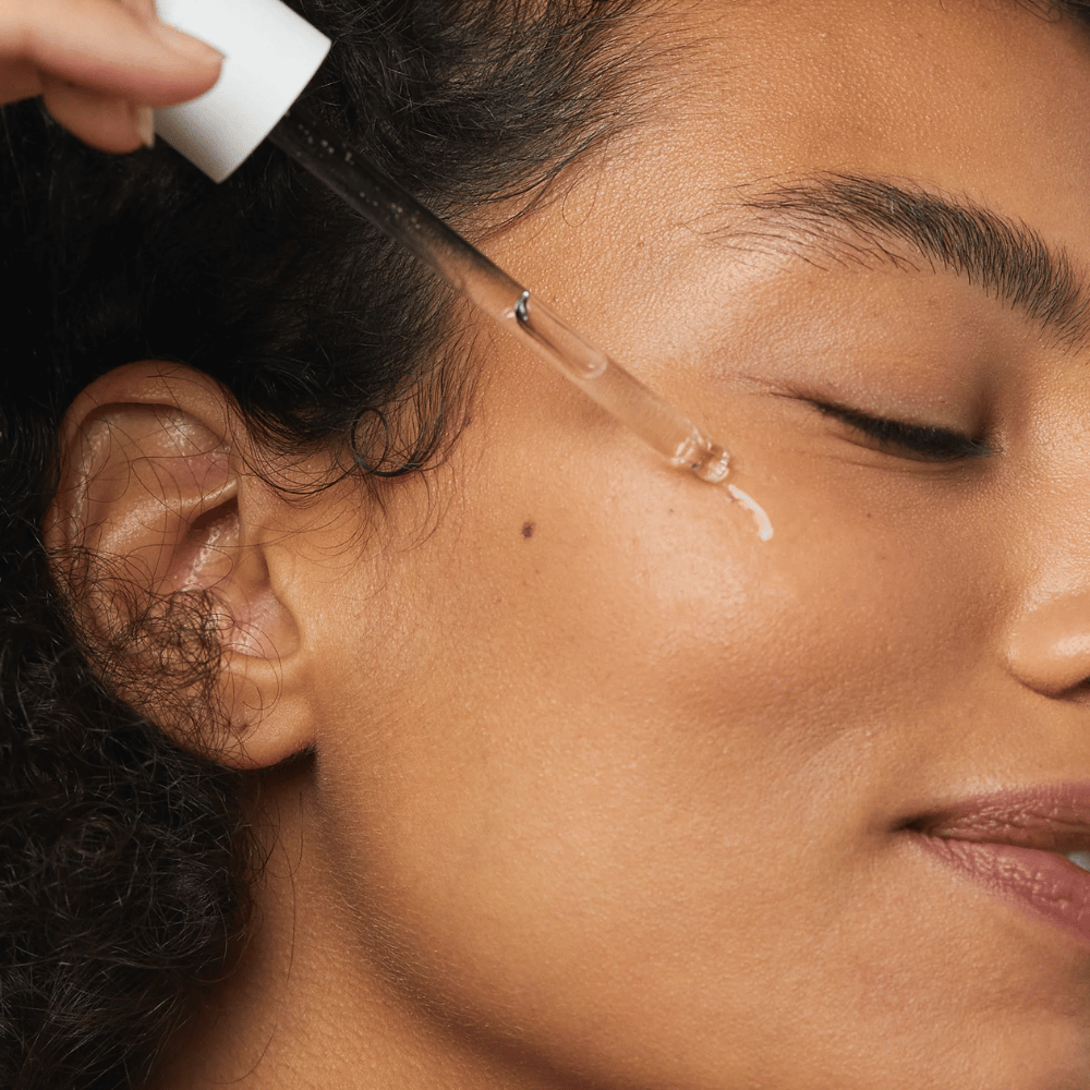 Γυναίκα εφαρμόζει Skin1004 Madagascar Centella Hyalu-Cica First Ampoule στο μάγουλο με πιπέτα.