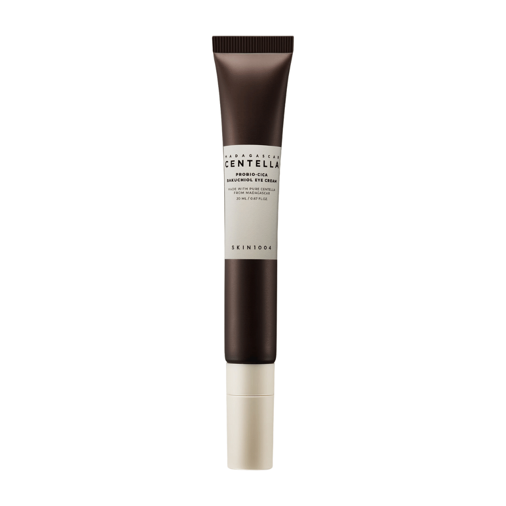 Ένας σωλήνας από "Madagascar Centella Probio-Cica Bakuchiol Eye Cream" από SKIN1004. Το προϊόν είναι σχεδιασμένο για την περιοχή των ματιών και περιέχει συστατικά όπως η centella από τη Μαδαγασκάρη και το bakuchiol, γνωστά για τις ιδιότητες τους στην περιποίηση και ενυδάτωση του δέρματος. Ο σωλήνας είναι κομψός με σκούρο καφέ χρώμα που μεταβαίνει σε λευκό.