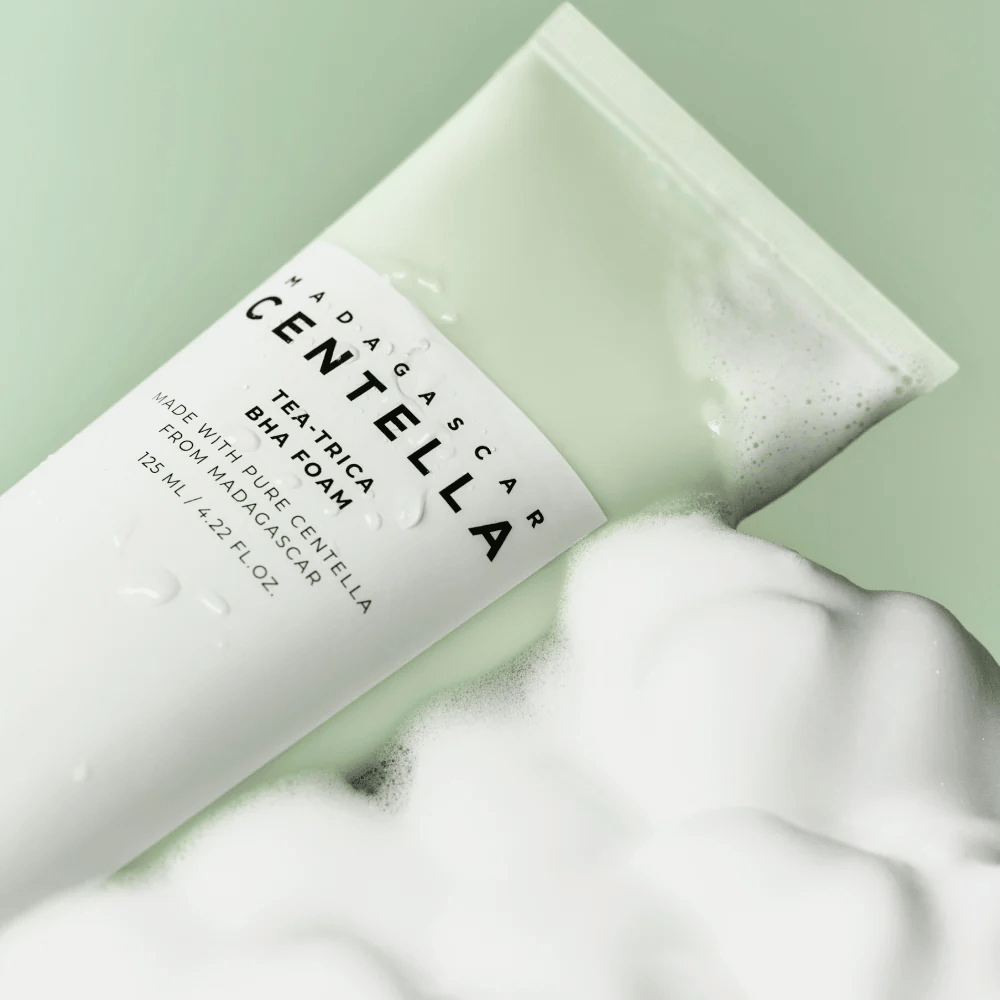 Ένα προϊόν τύπου αφρού καθαρισμού, "Madagascar Centella Tea-trica BHA Foam", είναι εν μέρει ορατό με αφρό γύρω του. Το προϊόν έχει πράσινο και λευκό σχέδιο, και το κείμενο "Madagascar Centella" και "Tea-trica BHA Foam" είναι εμφανώς ορατά. Ο όγκος είναι 125 ml.
