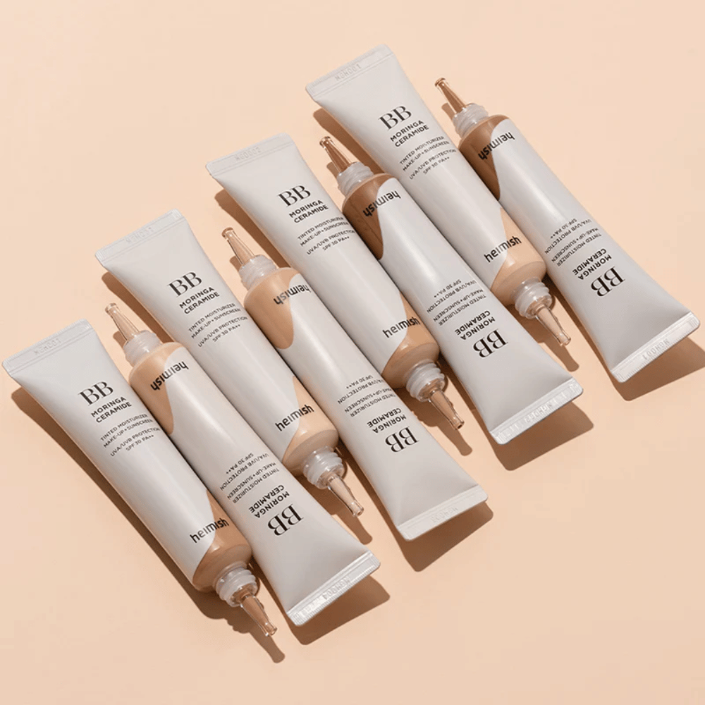 Πολλά σωληνάρια του Heimish Moringa Ceramide BB Cream τοποθετημένα σε ανοιχτό μπεζ φόντο. Η εικόνα αναδεικνύει τις διαφορετικές αποχρώσεις και τον κομψό, μινιμαλιστικό σχεδιασμό της συσκευασίας του προϊόντος.