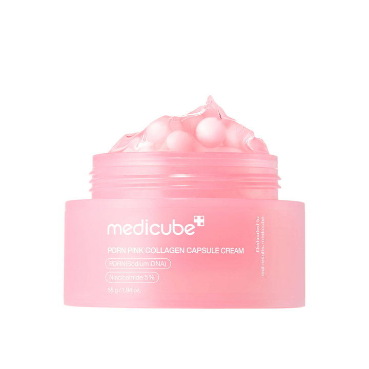 Εικόνα προϊόντος του Medicube PDRN Pink Collagen Capsule Cream με ορατές ροζ κάψουλες σε ένα διάφανο ροζ βάζο, σχεδιασμένο για να ενυδατώνει και να εξομαλύνει τον τόνο του δέρματος.