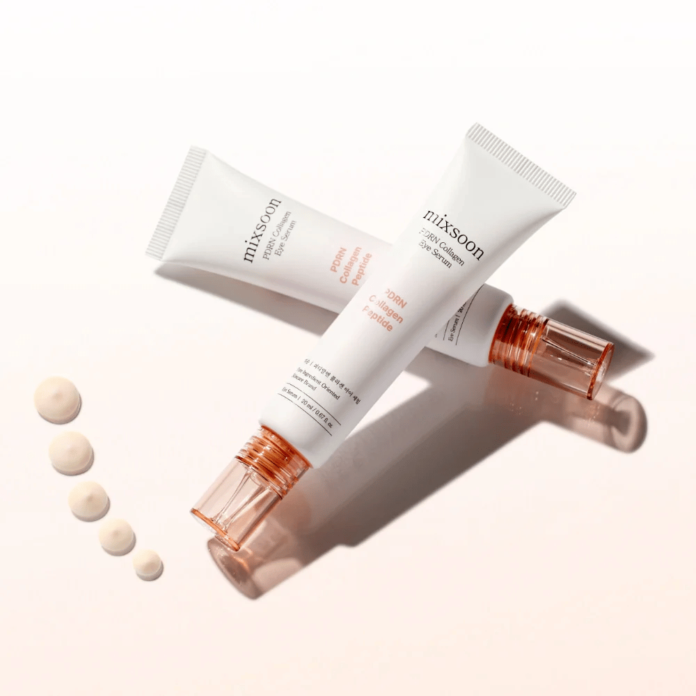 Δύο σωληνάρια Mixsoon PDRN Collagen Eye Serum είναι σταυρωμένα με μικρές σταγόνες του ορού. Μια ελαφριά θεραπεία ματιών που ενυδατώνει και εξομαλύνει τις γραμμές.