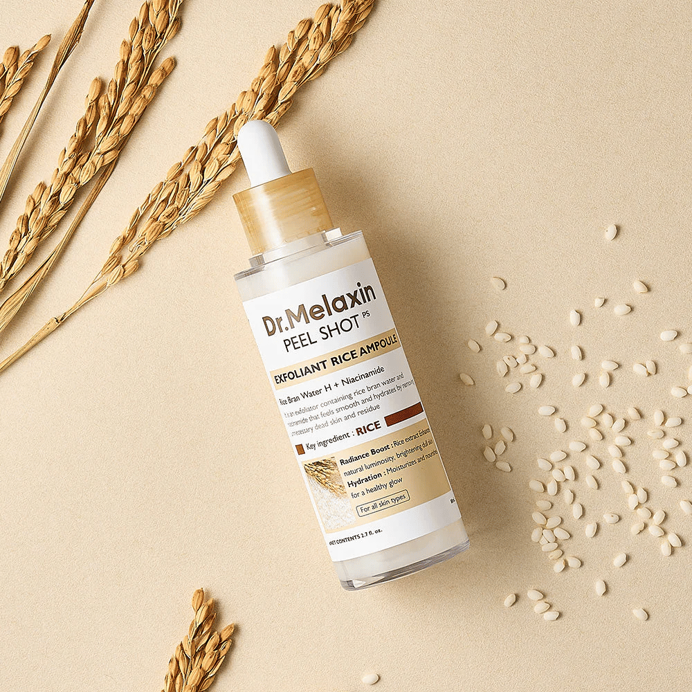 Dr.Melaxin Peel Shot Rice Ampoule τοποθετημένη σε αμμώδη επιφάνεια με ρύζι και στάχια, απολεπιστική αμπούλα προσώπου που συνδυάζει ήπια απολέπιση με εντατική ενυδάτωση.