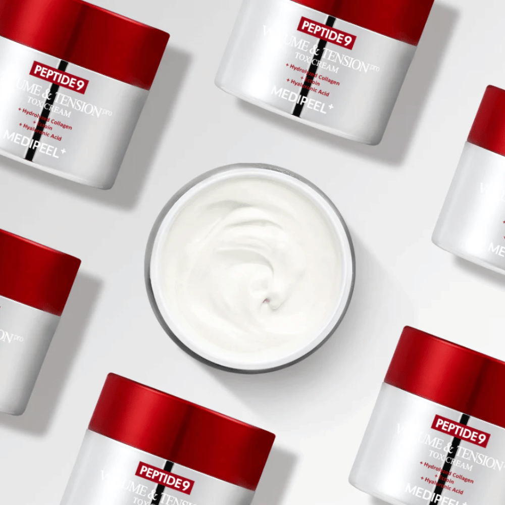 Πολλά βάζα της MEDI-PEEL Peptide 9 Volume & Tension Tox Cream τοποθετημένα σε λευκό φόντο. Το προϊόν ενυδατώνει έντονα και προσφέρει στο δέρμα όγκο και λάμψη.