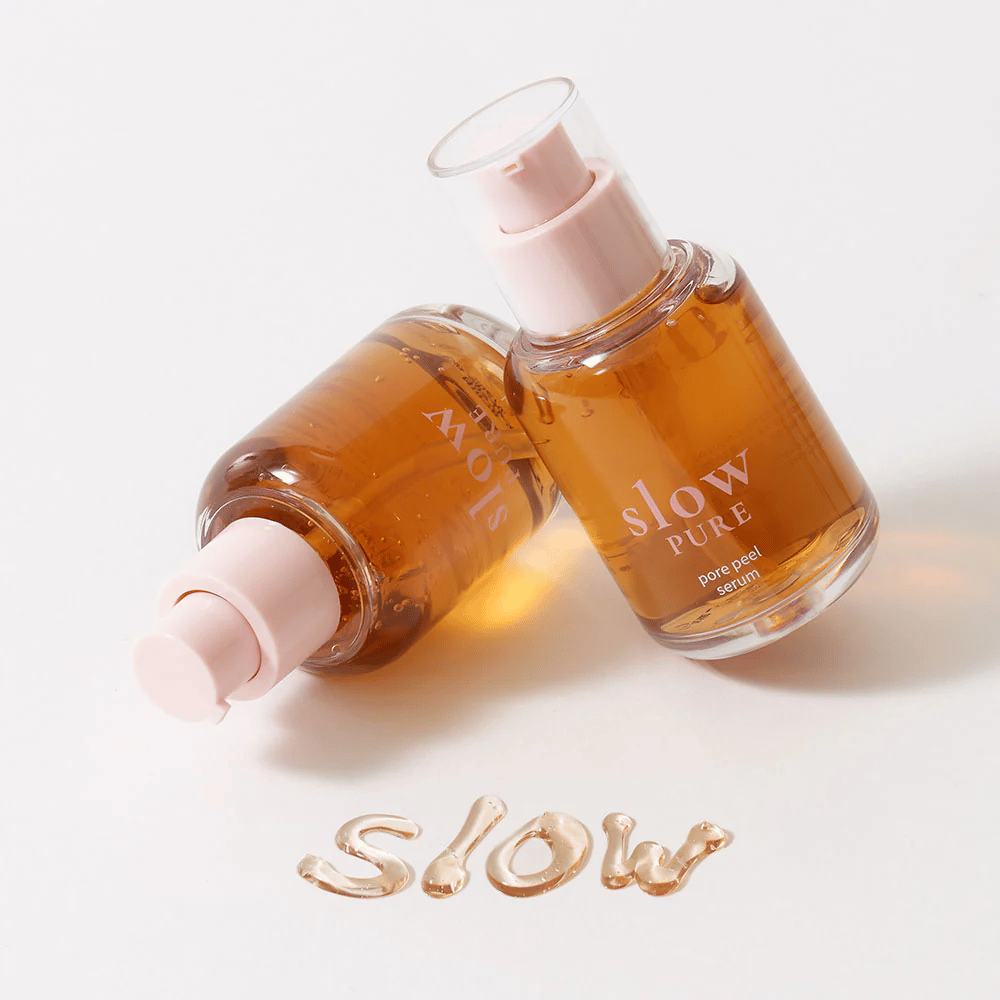 Δύο μπουκάλια Slow Pure Pore Peel Serum με αντλία, κείμενο γραμμένο με ορό στην επιφάνεια: "Slow".