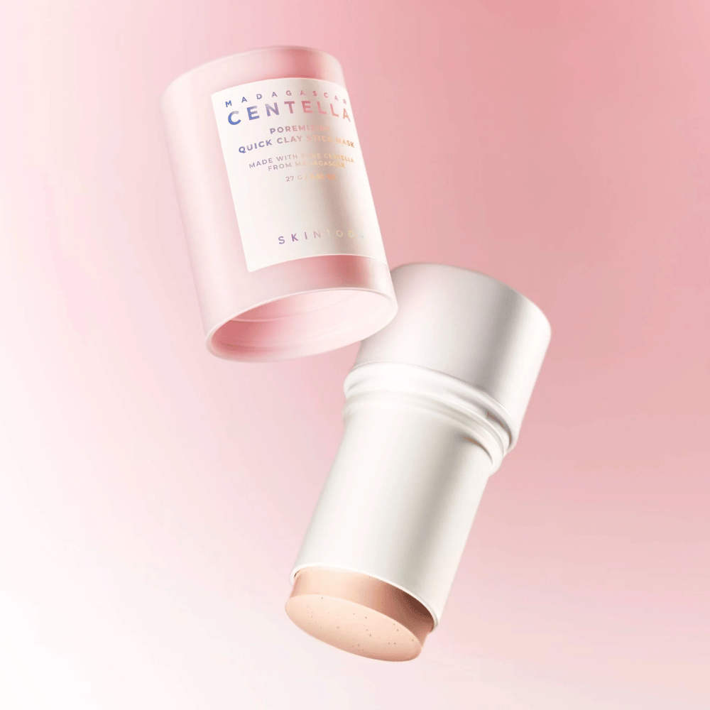 SKIN1004 Madagascar Centella Poremizing Quick Clay Stick Mask σε έναν κομψό ροζ και λευκό σχεδιασμό. Πρακτική μορφή στικ για εύκολη εφαρμογή και βαθύ καθαρισμό.