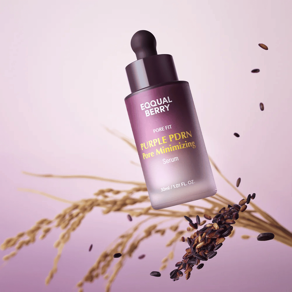 Μπουκάλι με Equal Berry Purple PDRN Pore Minimizing Serum αιωρείται σε μωβ φόντο, περιτριγυρισμένο από μαύρους κόκκους ρυζιού και άχυρα ρυζιού.