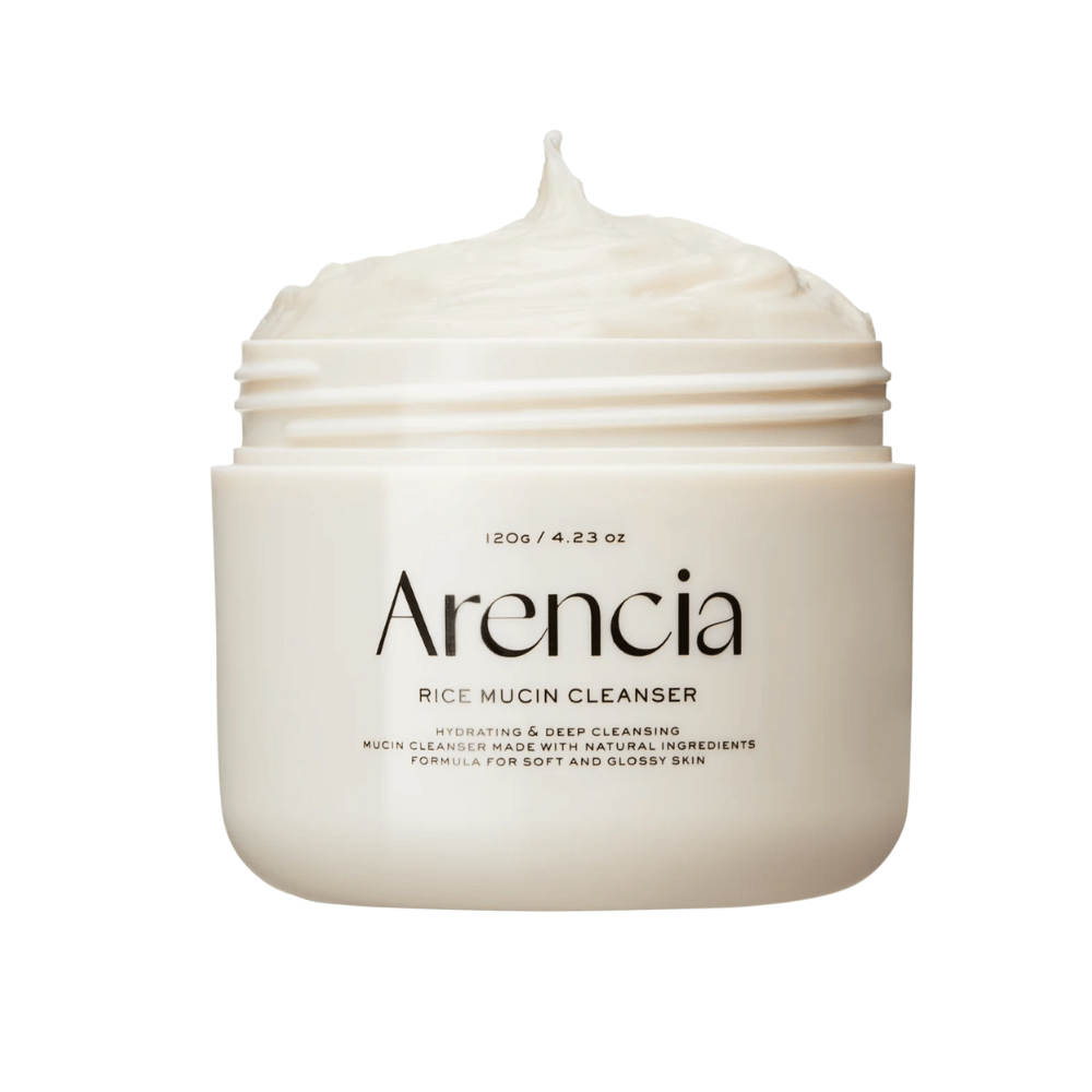 Εικόνα προϊόντος στο Arencia Rice Mucin Cleanser σε ένα λευκό δοχείο με κρεμώδη, χτυπημένη υφή που προεξέχει από το άνοιγμα. Το κείμενο στη συσκευασία τονίζει την ενυδάτωση και τον βαθύ καθαρισμό.