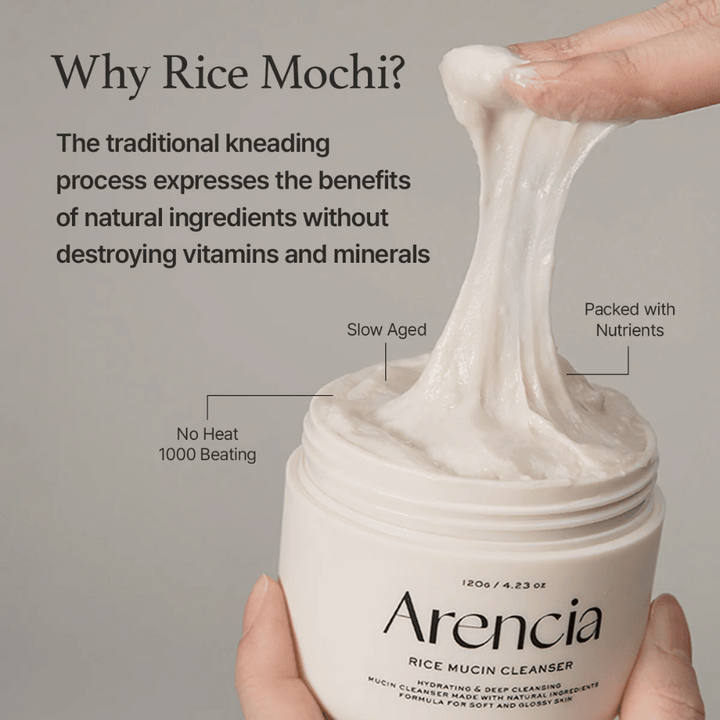 Hand som lyfter upp en elastisk, vit rengöringskräm ur en burk märkt "Arencia Rice Mucin Cleanser". Texten beskriver traditionell knådning som bevarar näringsämnen utan att förstöra vitaminer och mineraler.