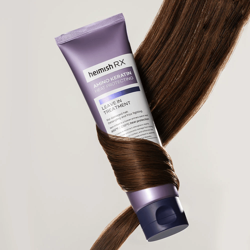 Heimish RX Amino Keratin Leave-In Treatment – θρεπτική θεραπεία μαλλιών που προστατεύει από τη θερμότητα, περιτριγυρισμένη από γυαλιστερά μαλλιά, συμβολίζει την ενισχυτική και ενυδατική επίδραση για τα κατεστραμμένα μαλλιά.