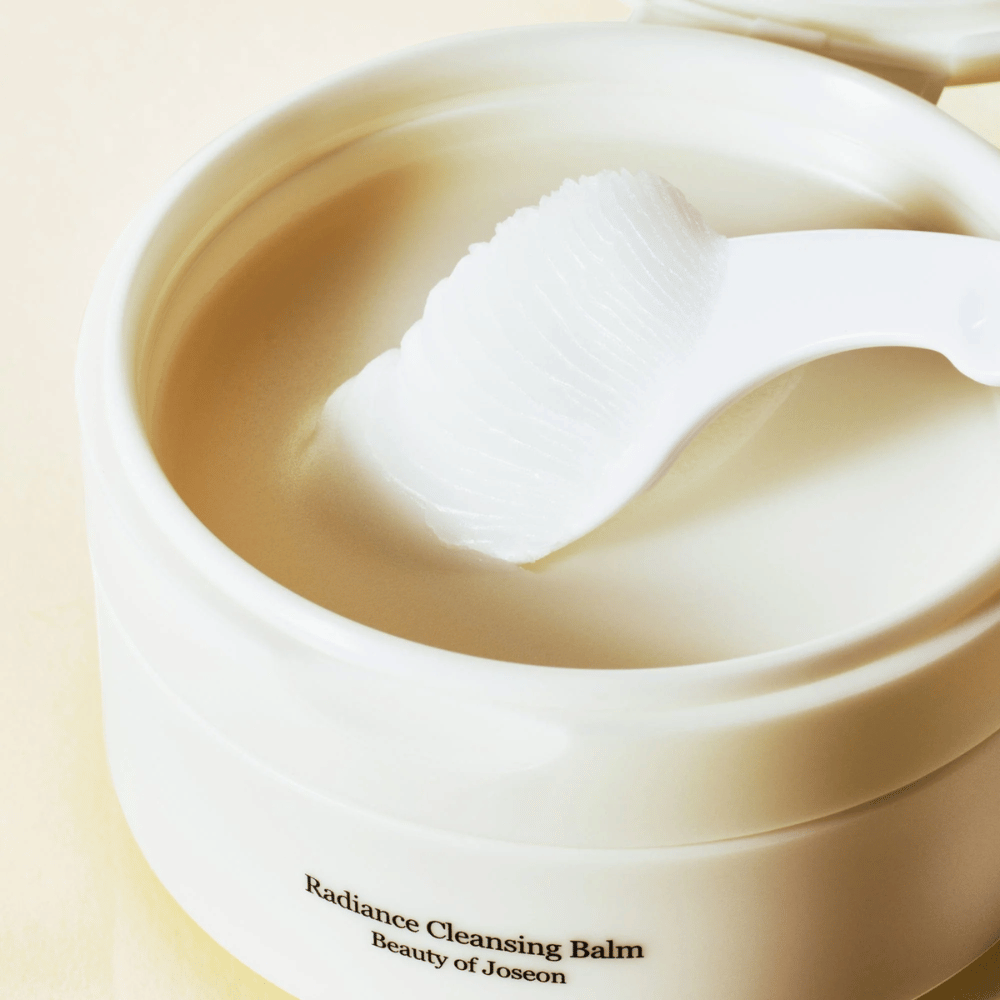 Κοντινή εικόνα στο Beauty of Joseon Radiance Cleansing Balm σε δοχείο με σπάτουλα – βάλσαμο μεταξένιας υφής που καθαρίζει και ενυδατώνει.
