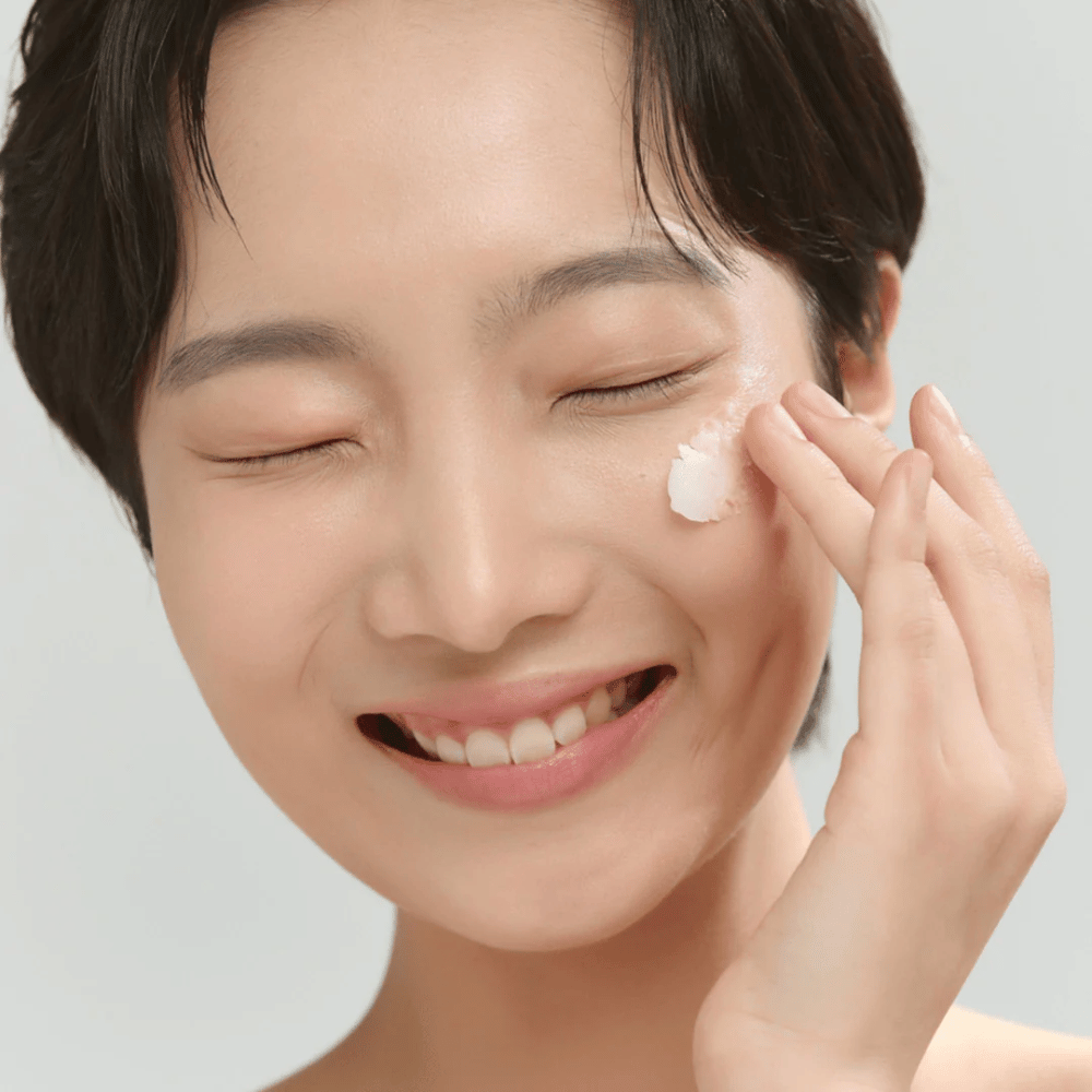 Μοντέλο με λαμπερό δέρμα εφαρμόζει Beauty of Joseon Radiance Cleansing Balm – κορεάτικο καθαριστικό βάλσαμο που λιώνει το μακιγιάζ και τις ακαθαρσίες.
