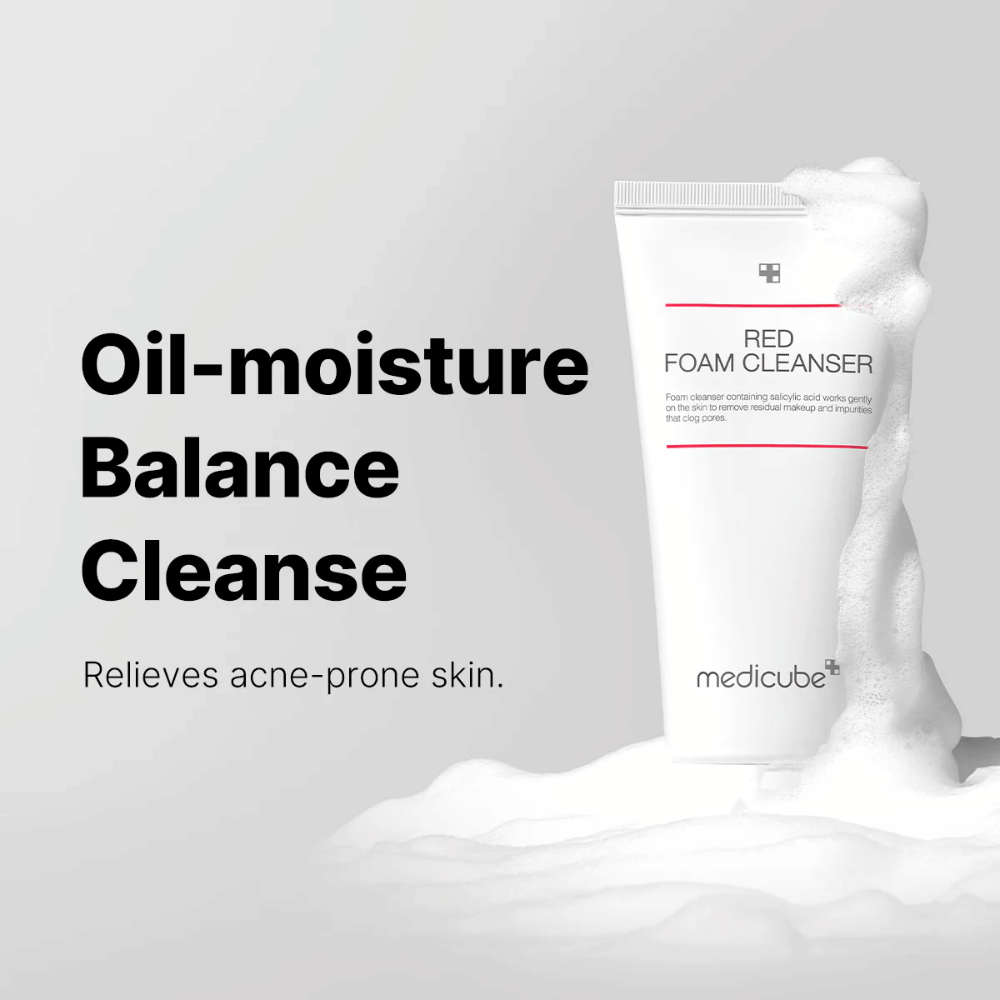 Σωλήνας με Medicube Red Foam Cleanser στέκεται όρθιος ανάμεσα σε αφρώδες σαπούνι. Το κείμενο "Oil-moisture Balance Cleanse" εμφανίζεται στα αριστερά, με την περιγραφή "Relieves acne-prone skin" από κάτω. Το φόντο είναι ανοιχτό γκρι.