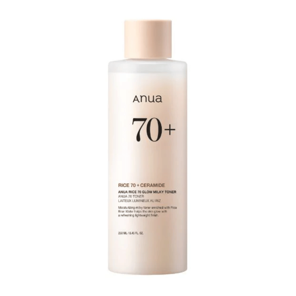 Ένα μπουκάλι "Anua 70+ Rice Ceramide Milky Toner". Αυτή η τονωτική λοσιόν έχει διαμορφωθεί για να φωτίζει και να δίνει λάμψη στο δέρμα, εμπλουτισμένη με νερό ρυζιού και κεραμίδια. Η συσκευασία είναι απλή και κομψή με μια απαλή μπεζ απόχρωση και μια διακριτική ετικέτα.