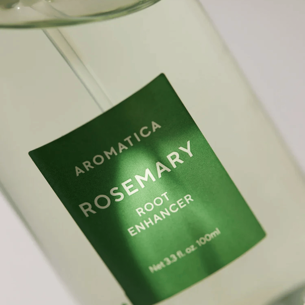 Λεπτομερής εικόνα της ετικέτας στο AROMATICA Rosemary Root Enhancer. Η πράσινη ετικέτα και το διαφανές μπουκάλι αναδεικνύουν την καθαρή και μινιμαλιστική εμφάνιση του προϊόντος.