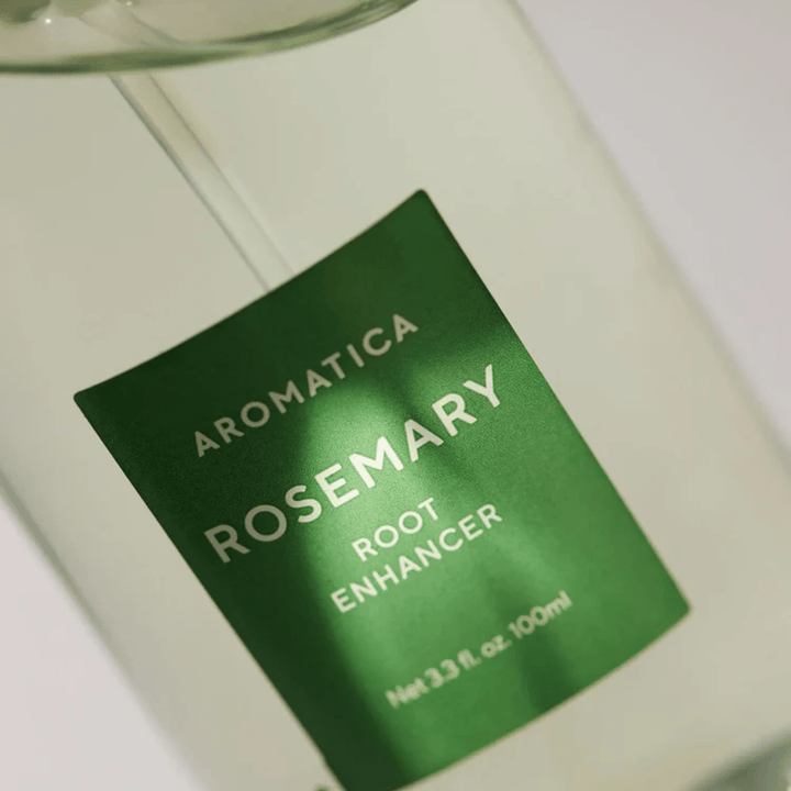 Λεπτομερής εικόνα της ετικέτας στο AROMATICA Rosemary Root Enhancer. Η πράσινη ετικέτα και το διαφανές μπουκάλι αναδεικνύουν την καθαρή και μινιμαλιστική εμφάνιση του προϊόντος.