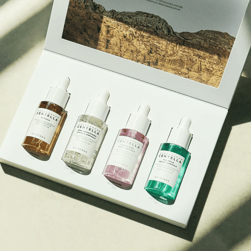 Ένα κουτί που περιέχει Madagascar Centella Ampoule Kit από SKIN1004, το οποίο περιέχει τρία διαφορετικά είδη προϊόντων περιποίησης δέρματος για ενυδάτωση και ενυδάτωση.