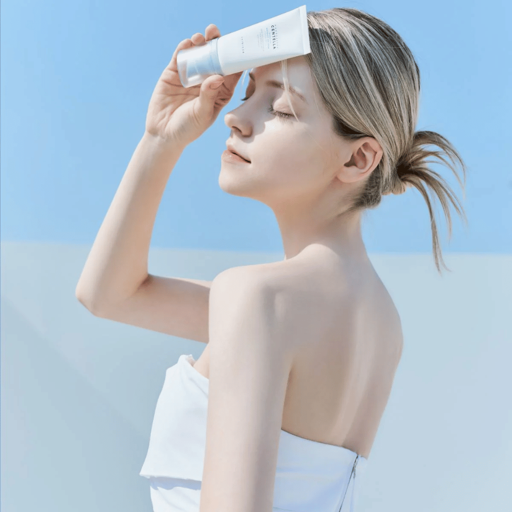 Μια γυναίκα εφαρμόζει SKIN1004 Madagascar Centella Hyalu-Cica Water-Fit Sun Serum 50ml για να προστατεύσει το πρόσωπο από τις ακτίνες UV.