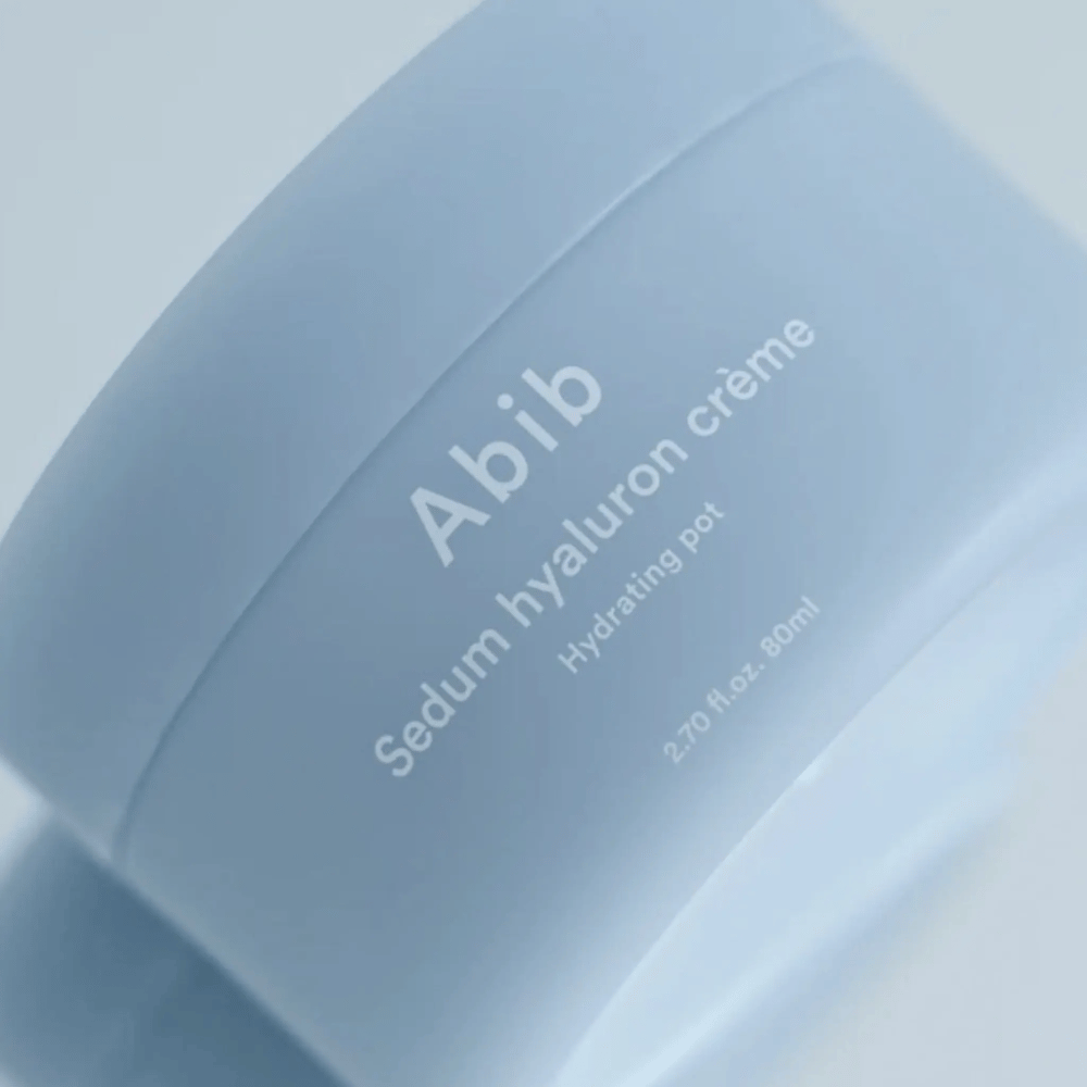 Κοντινή λήψη του Abib Sedum Hyaluron Crème Hydrating Pot 80 ml σε ένα ανοιχτό μπλε δοχείο με μινιμαλιστικό σχεδιασμό σε ουδέτερο φόντο.