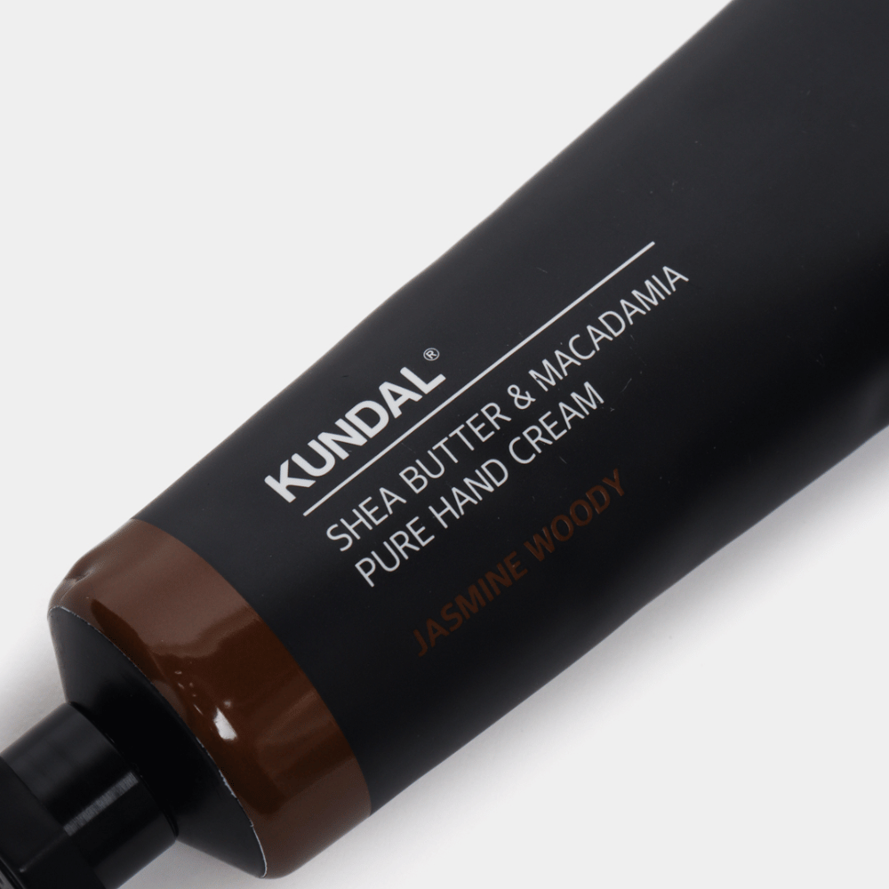 Κοντινή λήψη του KUNDAL Shea Butter & Macadamia Pure Hand Cream Jasmine Woody που δείχνει τη κομψή συσκευασία και την αίσθηση premium της κρέμας χεριών.