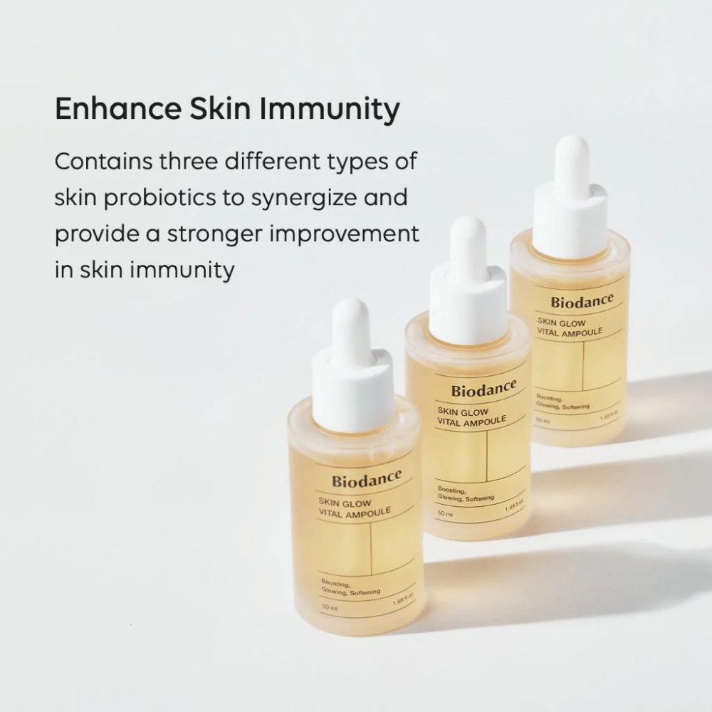 Τρία μπουκάλια του Biodance Skin Glow Vital Ampoule εμφανίζονται με το κείμενο 'Enhance Skin Immunity'. Το προϊόν περιέχει τρεις διαφορετικούς τύπους προβιοτικών δέρματος που ενισχύουν την ανοσία του δέρματος και βελτιώνουν την προστασία του.
