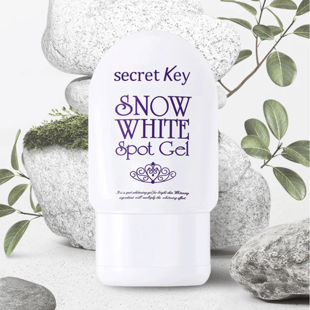 Secret Key Snow White Spot Gel φωτογραφημένο με φόντο πέτρες και πράσινα φύλλα.