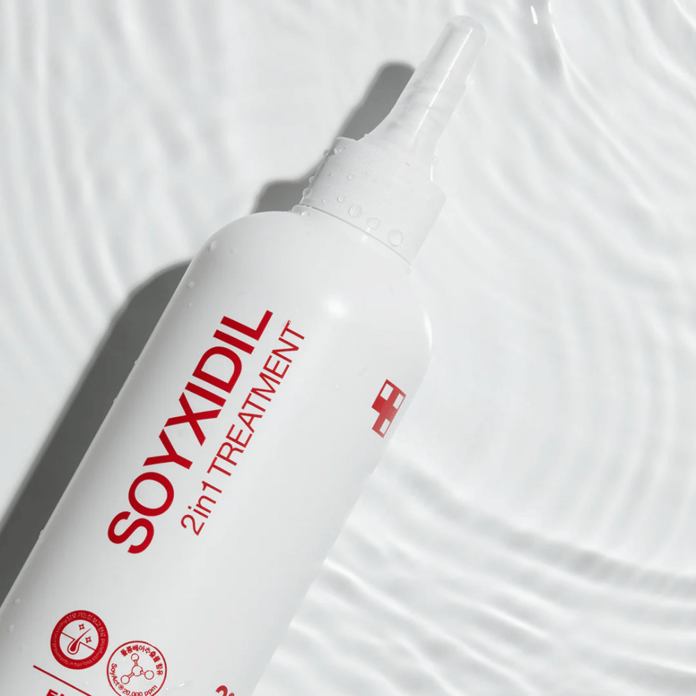 Μπουκάλι του Medicube Soyxidil 2in1 Treatment βρίσκεται σε κυματιστή υδάτινη επιφάνεια, που συμβολίζει ενυδατική και αναζωογονητική φροντίδα.