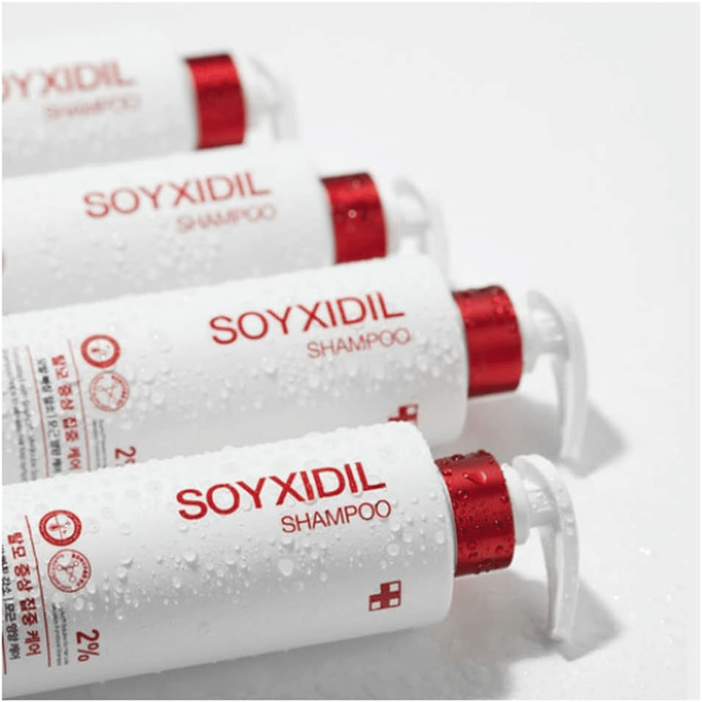 Πολλά μπουκάλια του Medicube Soyxidil Shampoo βρίσκονται στη σειρά με σταγόνες νερού – δείχνει τη φρέσκια και περιποιητική αίσθηση του προϊόντος.