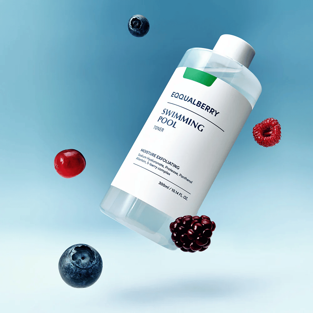Equalberry Swimming Pool Toner σε ένα κομψό μπουκάλι αιωρούμενο σε μπλε φόντο, περιτριγυρισμένο από φρέσκα μούρα όπως μύρτιλα, σμέουρα και βατόμουρα.
