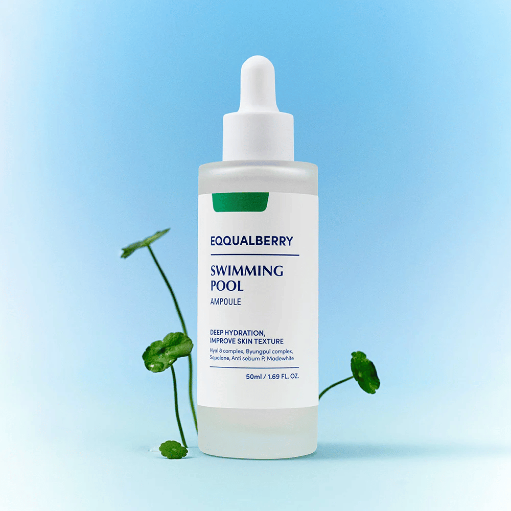 Μπουκάλι με Eqqualberry Swimming Pool Ampoule, ένα προϊόν περιποίησης δέρματος για βαθιά ενυδάτωση και βελτιωμένη υφή δέρματος, τοποθετημένο σε ένα ανοιχτό μπλε φόντο με μερικά πράσινα φυτά στο προσκήνιο.