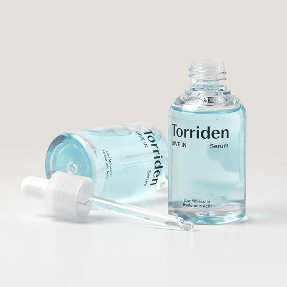 Ένα μπουκάλι Torridens DIVE-IN Low Molecule Hyaluronic Acid Serum 50ml δίπλα σε ένα μπουκάλι νερό, που τονίζει τον ορό με υαλουρονικό οξύ και την ενυδάτωση.