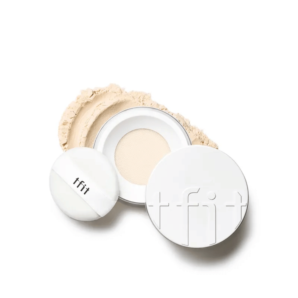 Ανοιχτό κουτί με TFIT Translucent Set Finishing Powder στην απόχρωση Skin Beige, με συνοδευτικό πούφ και Πούδρα διασκορπισμένο γύρω.
