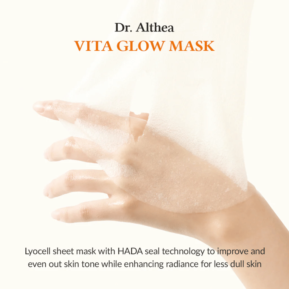 Χέρι κρατάει μια μάσκα φύλλου lyocell από Dr. Althea Vita Glow Mask. Η μάσκα βελτιώνει τη λάμψη και την ομοιομορφία του δέρματος με την τεχνολογία HADA Seal.