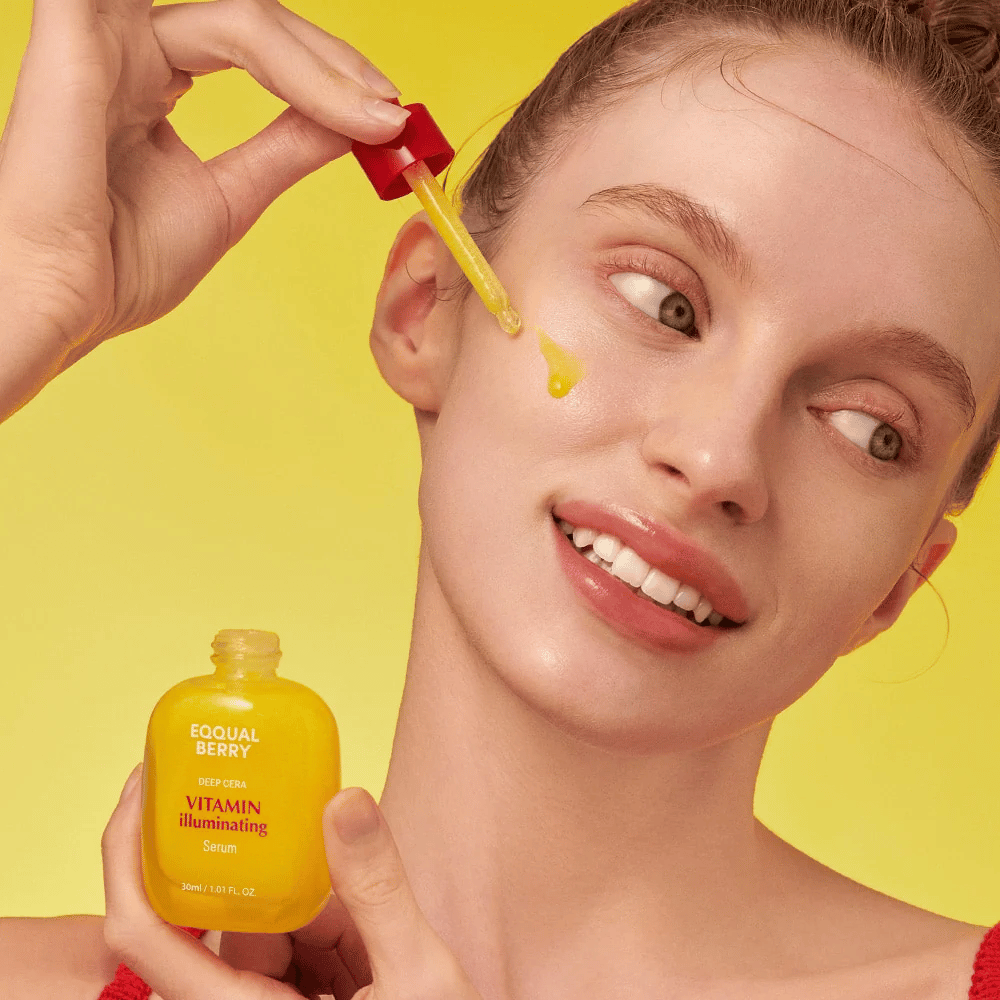 Χαμογελαστή γυναίκα εφαρμόζει το Equal Berry Vitamin Illuminating Serum με μια πιπέτα. Φρέσκο και λαμπερό δέρμα με φόντο ένα ζωηρό κίτρινο που ταιριάζει με το χρώμα του ορού.