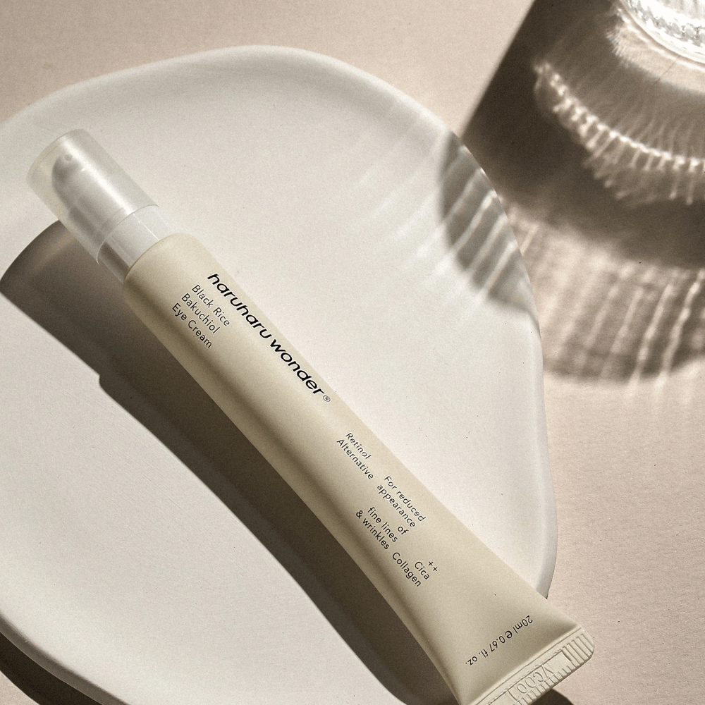 HaruHaru Wonder Black Rice Bakuchiol Eye Cream 20 ml – κρέμα ματιών με μαύρο ρύζι, bakuchiol και κολλαγόνο που μειώνει τις λεπτές γραμμές και ρυτίδες, τοποθετημένη σε κεραμικό πιάτο σε απαλό φως.