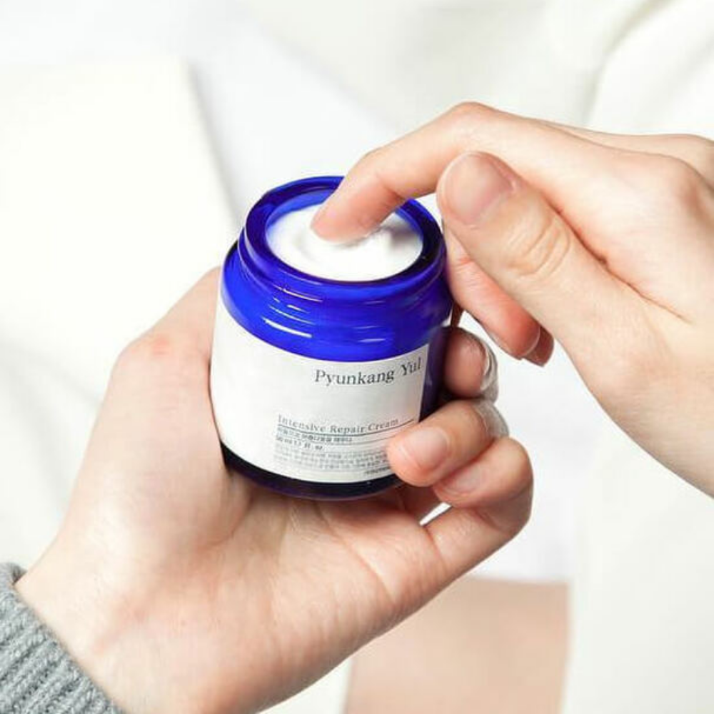 Ένα άτομο κρατάει ένα βάζο Pyunkang Yul Intensive Repair Cream 50ml.