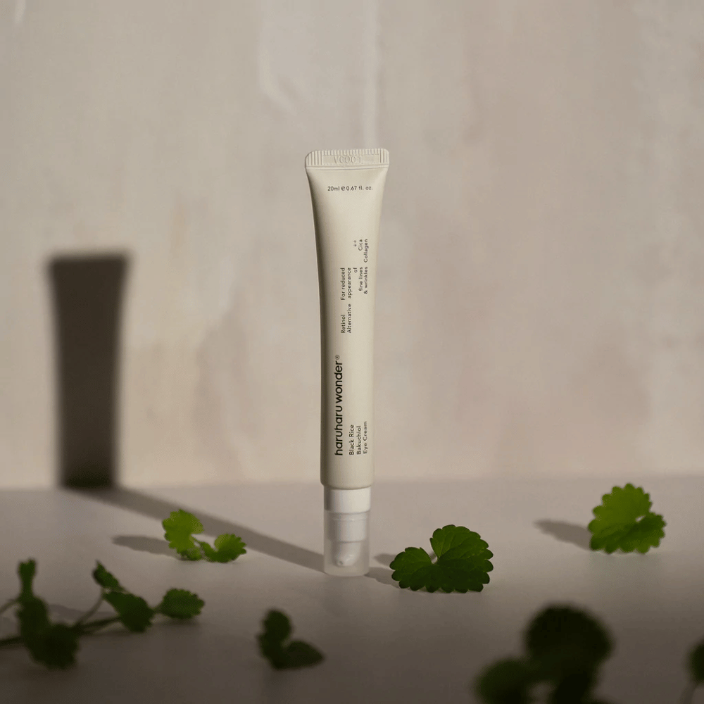 Ένας σωλήνας Haruharu Wonder Black Rice Bakuchiol Eye Cream 20ml περιτριγυρισμένος από πράσινα φύλλα, εστιασμένος στην ορατότητα των ρυτίδων και λεπτών γραμμών.