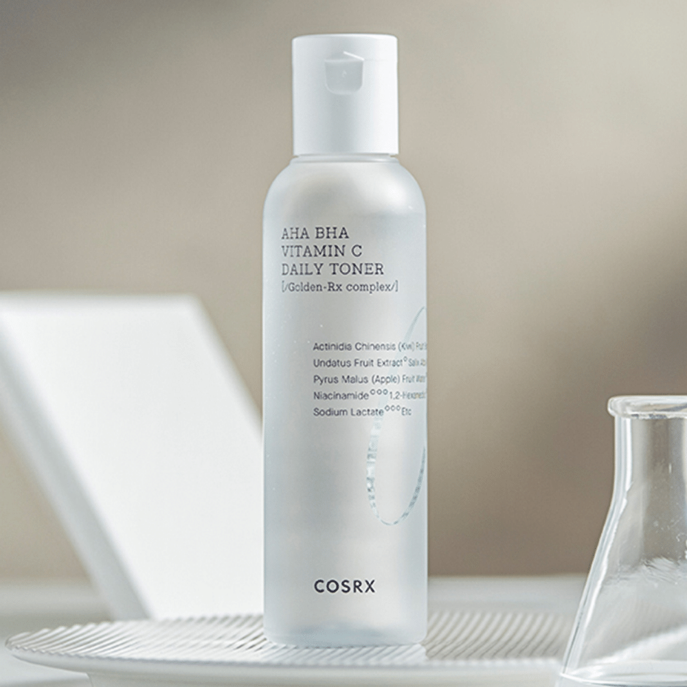 Ένα μπουκάλι COSRX Refresh AHA BHA Vitamin C Daily Toner 150ml που κάθεται πάνω σε μια λευκή πλάκα.