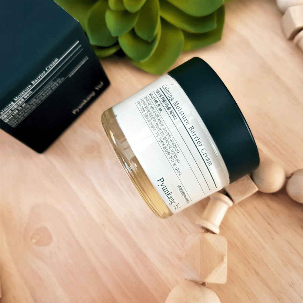 Ένα βάζο Pyunkang Yul Calming Moisture Barrier Cream 50ml που βρίσκεται πάνω σε ένα ξύλινο τραπέζι.