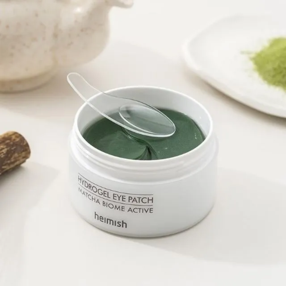 Ένα μπολ με Heimish Matcha Biome Hydrogel Eye Patch 60 τσιρότα με ένα κουτάλι.
